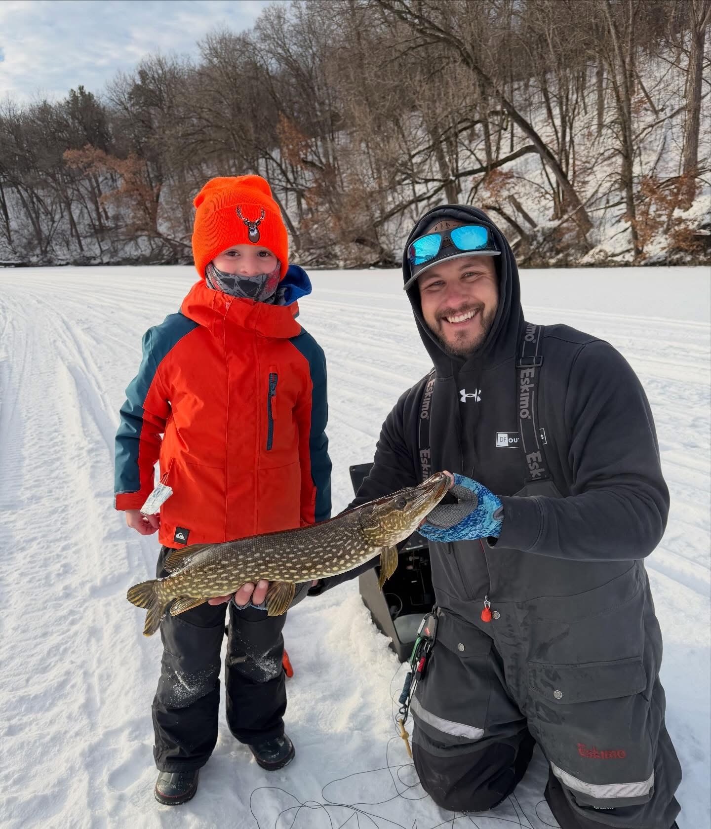 Dom and a young ice-fishing client holding a northern pike on a Wisconsin lake